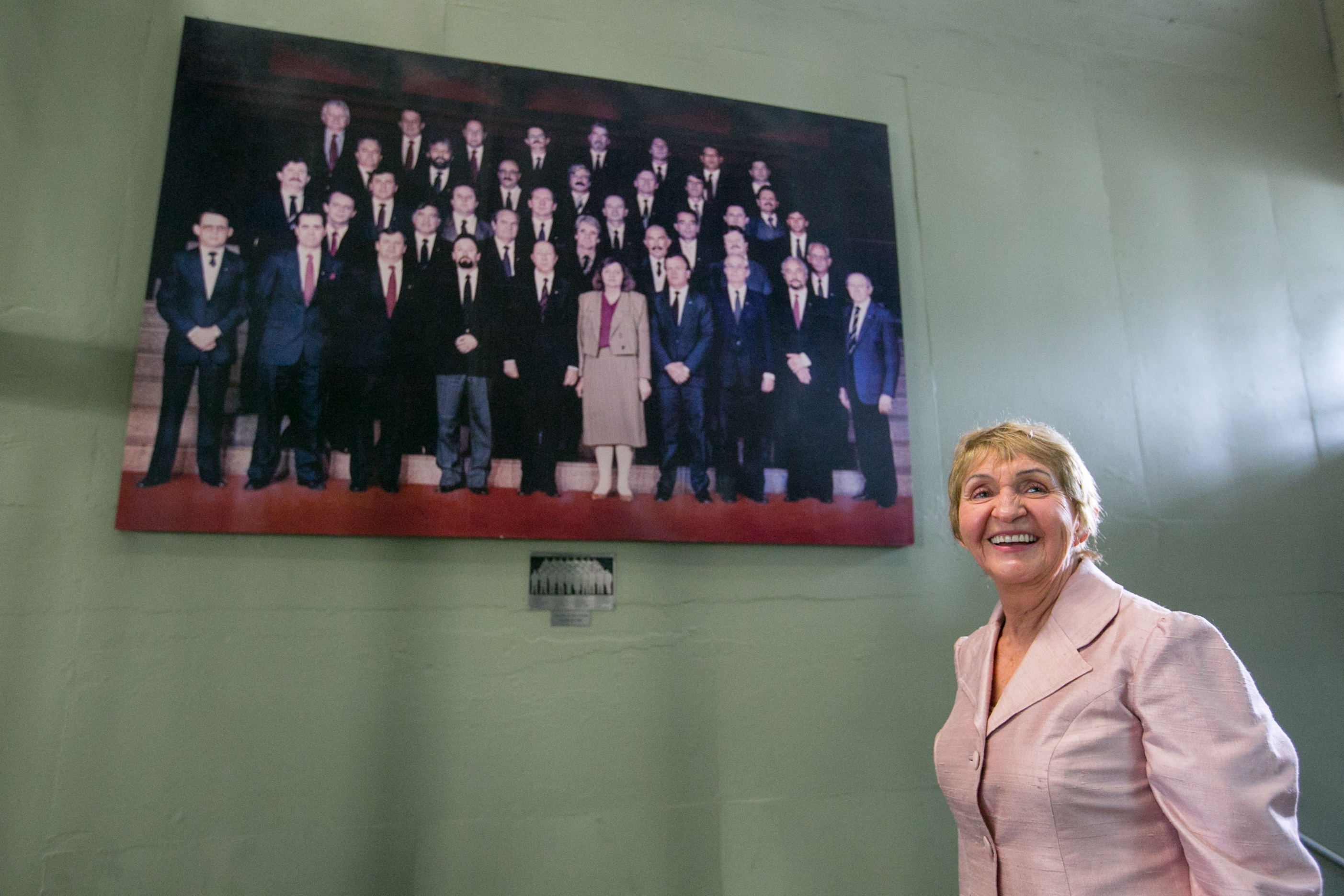 Luci Choinacki, ao lado da foto dos constituintes de 1989; ela era a única mulher entre os 40 deputados 