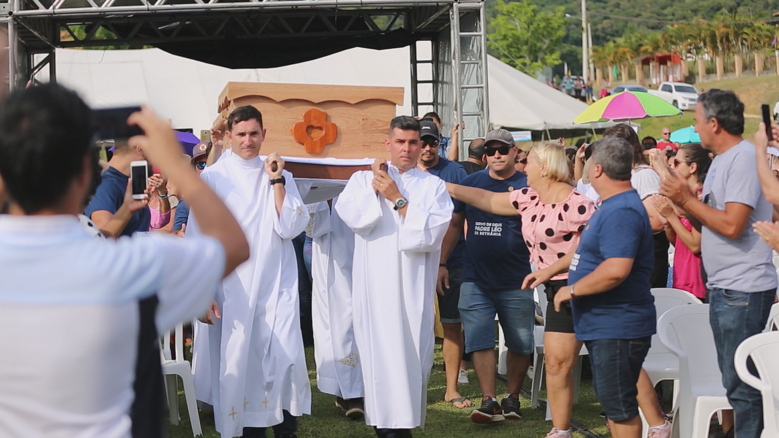 Público aplaude a passagem dos restos mortais de padre Léo