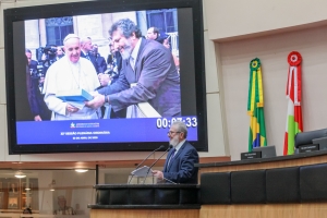 Sacerdote e deputado Padre Pedro discursa na Alesc com foto projetada de seu encontro com o Papa Francisco em novembro de 2013, no Vaticano